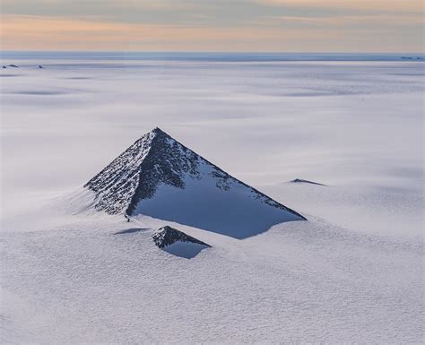 Such forms tend to be created by glacial activity, which, ahem, the ice-covered continent is known for. Much discussion of this in the related question in Skeptics: Are there three pyramids in Antarctica? Here's the generic answer in Wikipedia:. A pyramidal peak, sometimes in its most extreme form called a glacial horn, is an angular, sharply pointed …